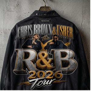 May include: Black denim jacket with a graphic design for the R&B Tour 2026 featuring Chris Brown and Usher. The design includes the text "CHRIS BROWN & USHER" above the words "R&B 2026 Tour". The jacket is suspended from a metal hanger.