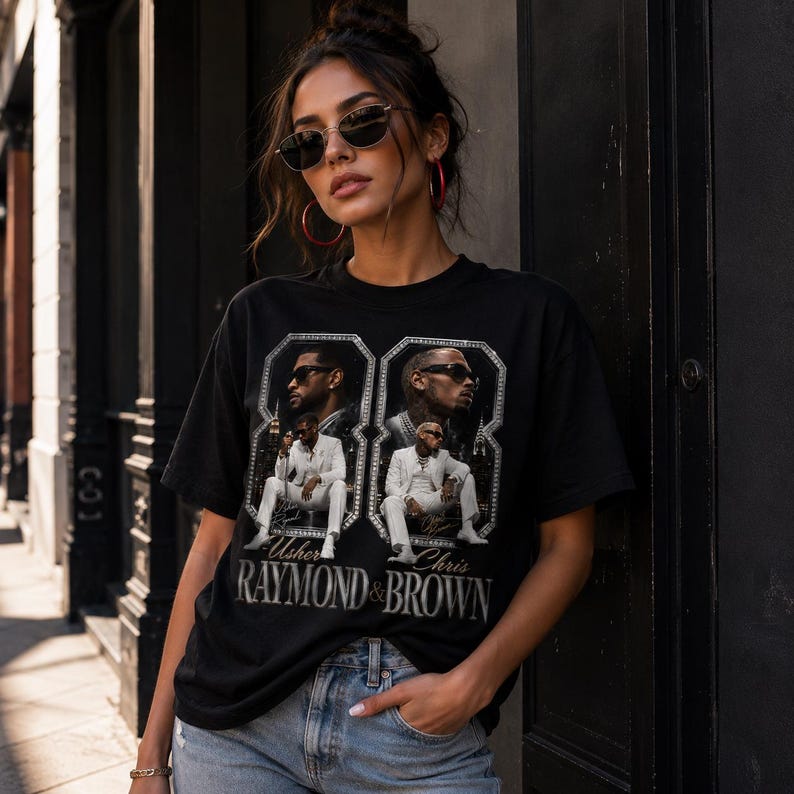 K&ouml;nnte beinhalten: Ein schwarzes Kurzarm-T-Shirt mit einem Grafikdruck von zwei Personen in wei&szlig;en Anz&uuml;gen. Das Design enth&auml;lt den Text Usher Raymond & Brown, zwei gerahmte Portr&auml;ts der Personen und eine gro&szlig;e Zahl 88 im Hintergrund.