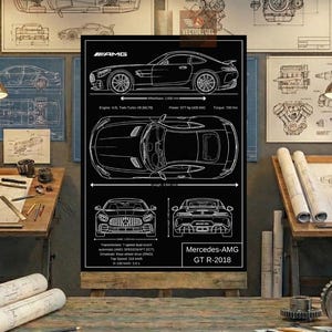 May include: Black and white blueprint-style poster of a Mercedes-AMG GT R-2018. The poster includes side, top, front, and rear views, along with specifications such as wheelbase, engine, power, and torque. The poster is displayed on a wooden desk.