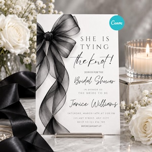 Puede incluir: Una tarjeta de invitación rectangular blanca para despedida de soltera con un gran lazo de cinta negra transparente en el lado izquierdo. El texto dice: SHE IS TYING the knot! JOIN US FOR THE Bridal Shower IN HONOR OF THE BRIDE TO BE Janice Williams.