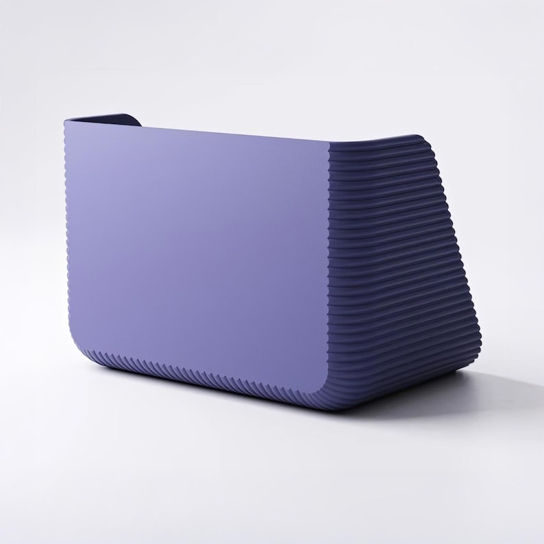 May include: A lavender-colored storage bin with a smooth front panel and a textured, ribbed side panel. The container features a rectangular shape with rounded corners and a deep, open-top design, constructed from a solid, matte-finish material.
