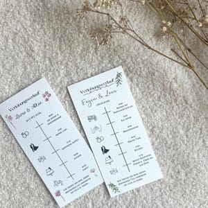 Könnte beinhalten: Zwei weiße Hochzeits-Zeitkarten mit schwarzem Text und Illustrationen, darunter Ringe, ein Brautpaar und eine Torte. Die Karten sind mit floralen Akzenten und dem Text "Verlobungsverlauf" verziert.
