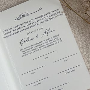 Może przedstawiać: Biały papierowy kontrakt małżeński z czarnym nadrukiem w języku tureckim, zawierający imiona Gulsen & Musa, werset z Koranu oraz linie do podpis&oacute;w dla pary młodej, imama i świadk&oacute;w, z suszoną gałązką rośliny u g&oacute;ry.