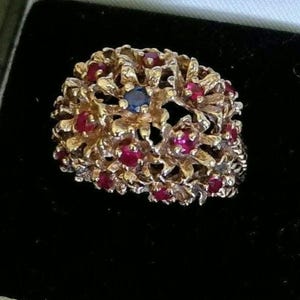 14K solid gold huge flower cluster ring 9 grams. Lab rubies, sapphire, size 6.75. Comes boxed as shown. Specific gravity and acid tested.