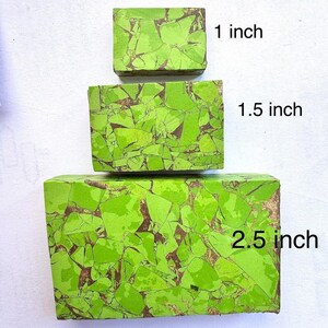 Könnte beinhalten: Drei rechteckige Blöcke aus grünem Stein mit braunen Adern. Die Blöcke sind 2,5 cm, 3,8 cm und 6,4 cm lang. Der Stein hat ein mosaikartiges Aussehen, mit Text, der die Größe jedes Blocks angibt.