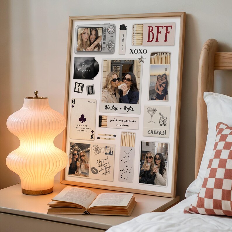 May include: A framed collage featuring photos, matchbox-style art, and text elements. The collage includes the text "BFF", "XOXO", "Hailey + Kylie", and "Cheers!". A lamp with a ribbed, light pink glass shade sits on a nightstand next to an open book.