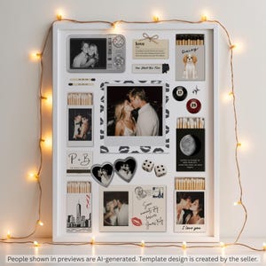 May include: A white framed collage featuring multiple black and white photographs, matchboxes with custom labels, a heart-shaped locket, two dice, and billiard balls numbered 17 and 25. The display includes text elements like love, NYC, and handwritten notes.