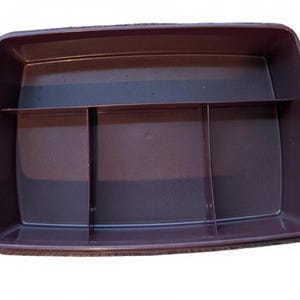 Puede incluir: Un recipiente de almacenamiento rectangular de plástico marrón oscuro con tres divisores internos. El recipiente tiene esquinas redondeadas y una superficie lisa. Los divisores crean cuatro compartimentos separados para organizar objetos.