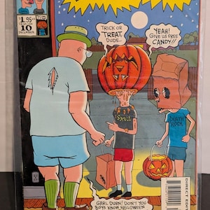 May include: A comic book cover featuring Beavis and Butt-Head in a Halloween scene. The comic has the Marvel Humor and MTV's logos. The characters are dressed in costumes, with one wearing a pumpkin head. Text includes "Trick or Treat, Dude..." and "Yeah! Give us free candy!!"