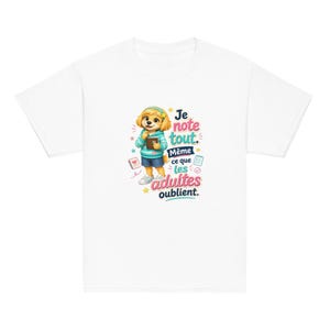 Peut inclure: Un t-shirt blanc avec un personnage de chien en dessin animé portant un sweat à capuche bleu sarcelle et un short bleu, tenant un carnet et un crayon. Le motif inclut le texte "Je note tout. Même ce que les adultes oublient." avec des étoiles.