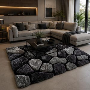 May include: A rectangular area rug featuring a high-pile, shaggy texture with a pattern of irregular, stone-like shapes in varying shades of charcoal, slate gray, and light silver, set against a deep black background with a soft, plush finish.