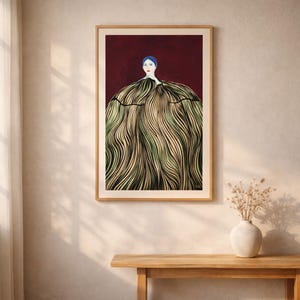 Puede incluir: Una impresión artística enmarcada que presenta una ilustración estilizada de una persona con cabello azul y labios rojos. La persona lleva un vestido con un patrón de líneas onduladas verdes y doradas sobre un fondo rojo oscuro.