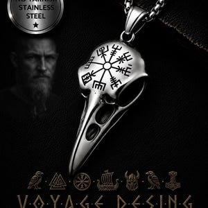 May include: A silver-colored pendant necklace featuring a raven skull design with a Viking compass symbol. The pendant hangs from a chain. The image also includes the text "NO TARNISH STAINLESS STEEL" and "VOYAGE DESING".