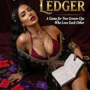 Könnte beinhalten: Spielschachtel-Cover von The Devil's Ledger mit einer Person in dunklem Gewand und rotem Spitzen-Bustier, die ein offenes Buch hält. Der Text lautet: Luna West Presents The Devil's Ledger, A Game for Two Grown-Ups Who Love Each Other, 40 Red, 50 Purple, 20 Black, 20 Gold, 130 Cards, Luna West, AmourAtelier, 18+.