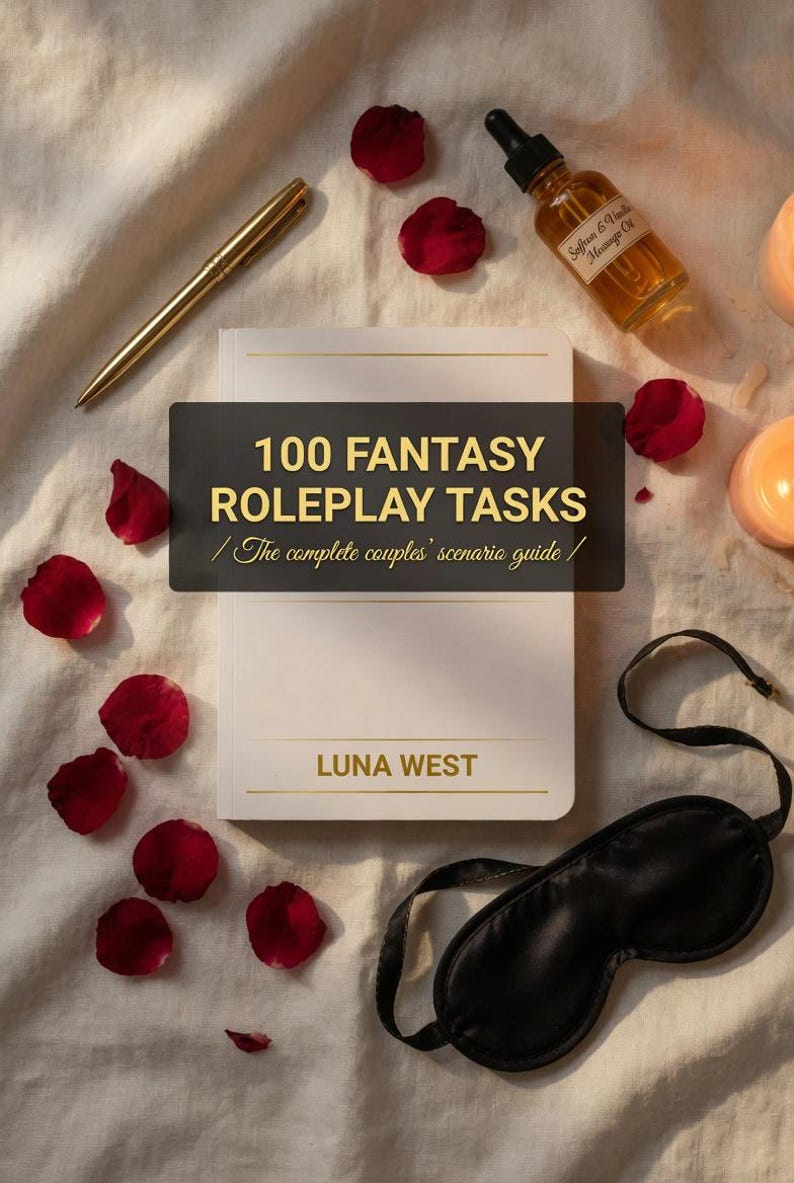 Puede incluir: Un libro blanco con detalles dorados, titulado "100 FANTASY ROLEPLAY TASKS", descansa sobre una s&aacute;bana blanca. Tambi&eacute;n hay un bol&iacute;grafo dorado, p&eacute;talos de rosa, una botella de aceite de masaje y una m&aacute;scara para los ojos negra.