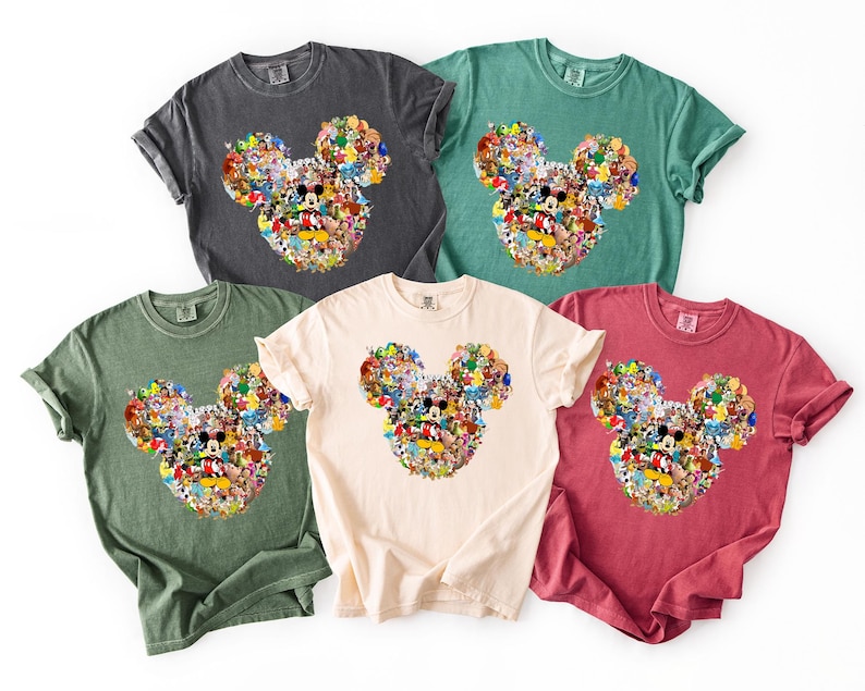 May include: Five short-sleeved t-shirts in various colors: charcoal, green, cream, red, and teal. Each shirt features a Mickey Mouse head design composed of numerous cartoon characters. The shirts are made of a soft, comfortable material.