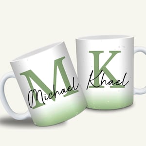 Könnte beinhalten: Zwei weiße Keramikbecher mit grünem Farbverlauf. Ein Becher zeigt den Buchstaben "M" und den Namen "Michael" in Schreibschrift. Der andere Becher zeigt den Buchstaben "K" und den Namen "Khael".