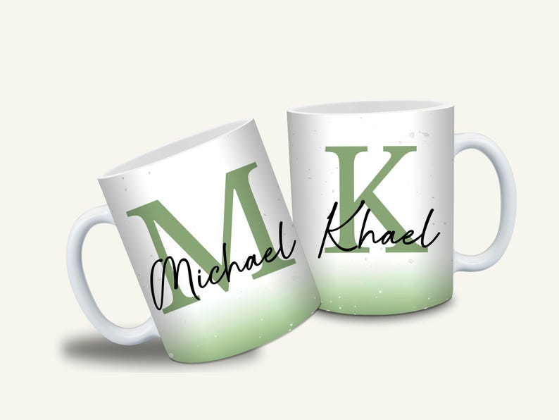 May include: Two white ceramic mugs with a green ombre effect. One mug displays the letter "M" and the name "Michael" in a script font. The other mug features the letter "K" and the name "Khael".