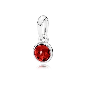 May include: A silver charm pendant with a round, faceted, deep red gemstone. The gemstone is set in a silver bezel and has a reflective surface. The pendant has a curved silver loop for attachment to a bracelet or necklace.