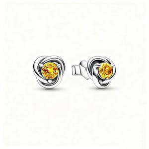 Puede incluir: Un par de pendientes de botón con una piedra preciosa de color amarillo brillante engastada en un diseño entrelazado de color plateado. Los pendientes tienen un poste y un respaldo, sobre un fondo blanco.