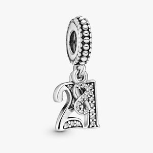Op de afbeelding: Een zilveren bedel met het nummer 21, versierd met sprankelende, heldere kristallen. De bedel heeft een kralen bovenkant voor bevestiging aan een armband of ketting. Het nummer 21 is een populaire keuze voor verjaardagen of jubilea.