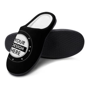 Pode incluir: Chinelo preto com interior branco e sola preta. O chinelo apresenta um design circular com o texto "YOUR DESIGN HERE" em branco. A sola tem um padr&atilde;o texturizado.