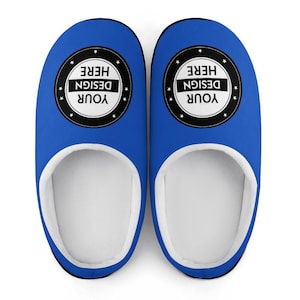 Pode incluir: Um par de chinelos azuis com interior branco e acabamento preto. Cada chinelo apresenta um design circular com o texto "YOUR DESIGN HERE" num design a preto e branco. Os chinelos s&atilde;o projetados para uso interno.