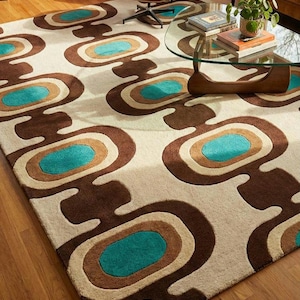 Puede incluir: Una alfombra rectangular con un dise&ntilde;o retro. La alfombra presenta un patr&oacute;n repetitivo de formas ovaladas marrones, beige y turquesas sobre un fondo crema. La alfombra est&aacute; hecha de un material suave y es adecuada para una sala de estar o un dormitorio.