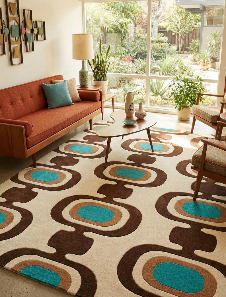 Puede incluir: Un sal&oacute;n de estilo retro con un sof&aacute; color &oacute;xido, sillas de madera y una alfombra estampada. La alfombra tiene un fondo crema con formas ovaladas marrones, turquesas y beige. Una mesa de centro y decoraci&oacute;n de pared completan el espacio.