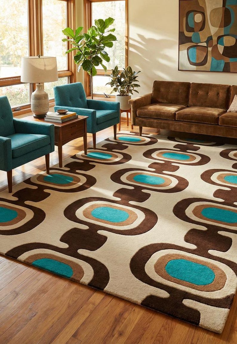 Puede incluir: Una alfombra de estilo retro con un fondo crema y formas ovaladas marrones, beige y turquesas repetidas. La alfombra est&aacute; colocada en un sal&oacute;n con sillones turquesas, un sof&aacute; marr&oacute;n y suelo de madera.