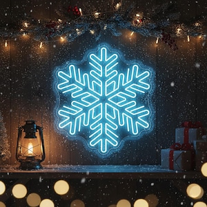 May include: A bright blue neon snowflake is displayed on a wooden wall, creating a festive winter scene. A vintage lantern with a lit bulb is on the left, and wrapped gifts are on the right. The scene is decorated with greenery and lights.