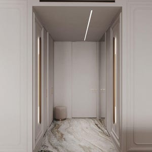 May include: An interior hallway with white walls, doors, and trim. The floor is a marble pattern with shades of brown, grey, and white. A small, round, beige ottoman sits near the doors. Gold accents are on the door frames and trim.