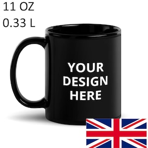 May include: A black ceramic mug with the text "YOUR DESIGN HERE" in white. The mug has a capacity of 0.33 L. A Union Jack flag is in the bottom right corner. The mug has a large handle for easy gripping.
