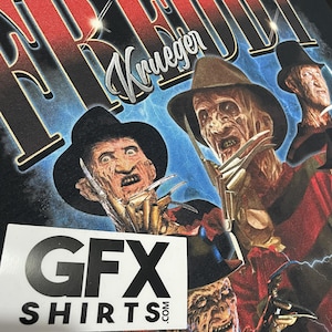 May include: Black t-shirt with a graphic of Freddy Krueger from the Nightmare on Elm Street films. The design includes multiple images of Krueger with his signature hat and bladed glove. The text "FREDDY Krueger" is printed across the top. The shirt also has a sticker that says "GFX SHIRTS.com".