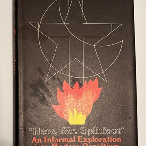 Puede incluir: Portada de libro vintage con fondo negro y formas geom&eacute;tricas blancas. La portada presenta el t&iacute;tulo "Here, Mr. Splitfoot" en blanco, con el nombre del autor, Robert Somerlott, en rojo. Un gr&aacute;fico de llama estilizado est&aacute; en la parte inferior.