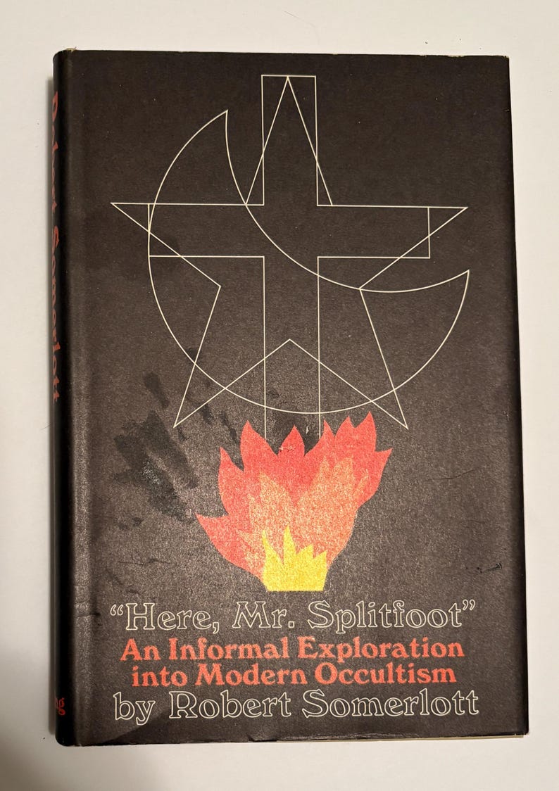 Puede incluir: Portada de libro vintage con fondo negro y formas geom&eacute;tricas blancas. La portada presenta el t&iacute;tulo "Here, Mr. Splitfoot" en blanco, con el nombre del autor, Robert Somerlott, en rojo. Un gr&aacute;fico de llama estilizado est&aacute; en la parte inferior.
