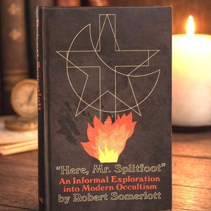 Puede incluir: Un libro de tapa dura negro con dise&ntilde;os geom&eacute;tricos dorados y una ilustraci&oacute;n de llama. El t&iacute;tulo es "Here, Mr. Splitfoot" de Robert Somerlott. El libro trata sobre ocultismo moderno.