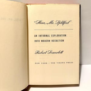 Puede incluir: Libro abierto con el t&iacute;tulo "Here, Mr. Splitfoot" y el subt&iacute;tulo "An Informal Exploration Into Modern Occultism". El nombre del autor, Robert Somerlott, est&aacute; debajo del t&iacute;tulo. Publicado por The Viking Press en Nueva York.