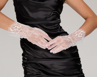 May include: White lace gloves with floral patterns. The gloves are fingerless, with intricate lace detailing around the wrists and fingers. The delicate design adds a touch of elegance. The gloves are a classic accessory.