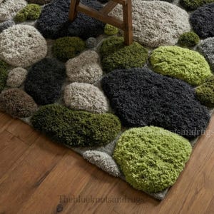 Modern hand-tufted beige wool rug with pebble pattern on balcony; 3D textured abstract carpet in gray, black, moss green.
