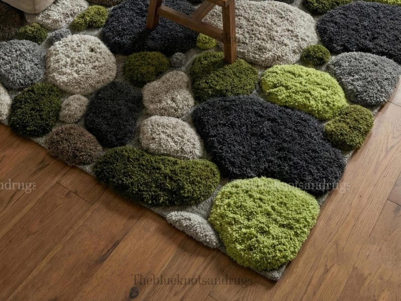 Modern hand-tufted beige wool rug with pebble pattern on balcony; 3D textured abstract carpet in gray, black, moss green.