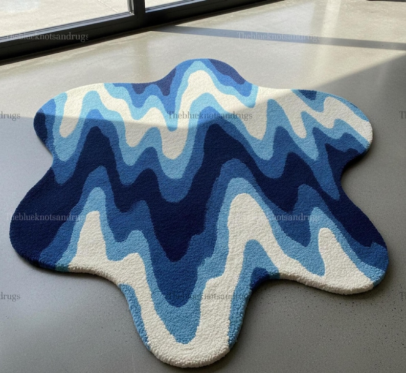 Hand-tufted wavy pattern rug in an irregular organic shape; ocean blue to navy blues with white cream, a textured plush melting rug.