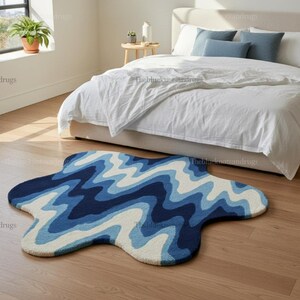 Hand-tufted wavy pattern rug in an irregular organic shape; ocean blue to navy blues with white cream, a textured plush melting rug.