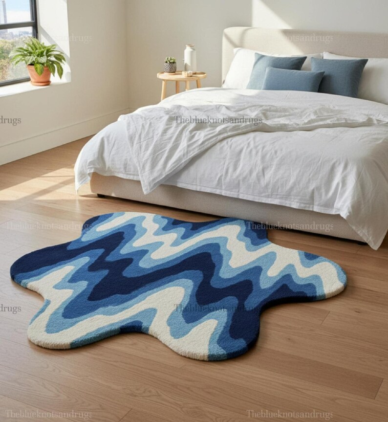 Hand-tufted wavy pattern rug in an irregular organic shape; ocean blue to navy blues with white cream, a textured plush melting rug.