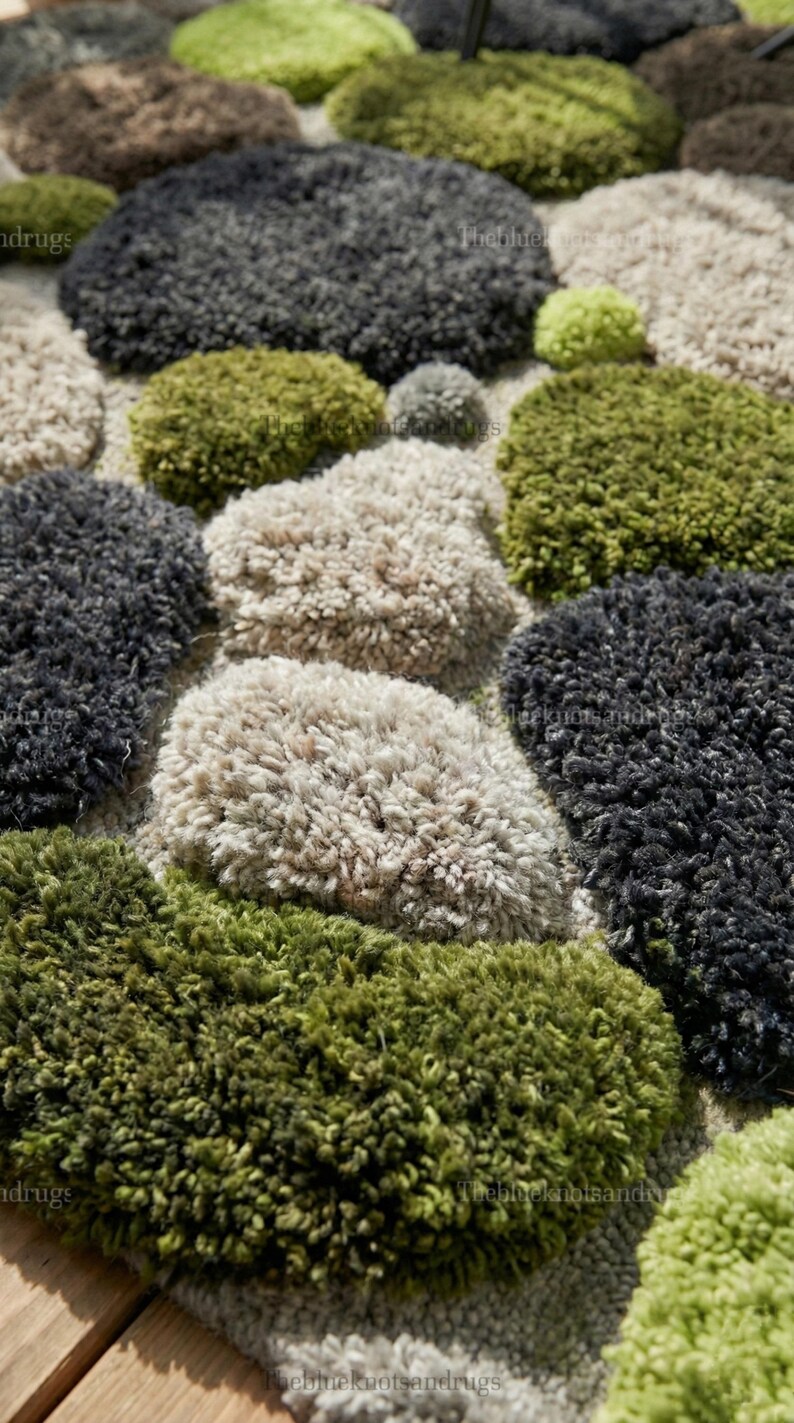 Modern hand-tufted beige wool rug with pebble pattern on balcony; 3D textured abstract carpet in gray, black, moss green.