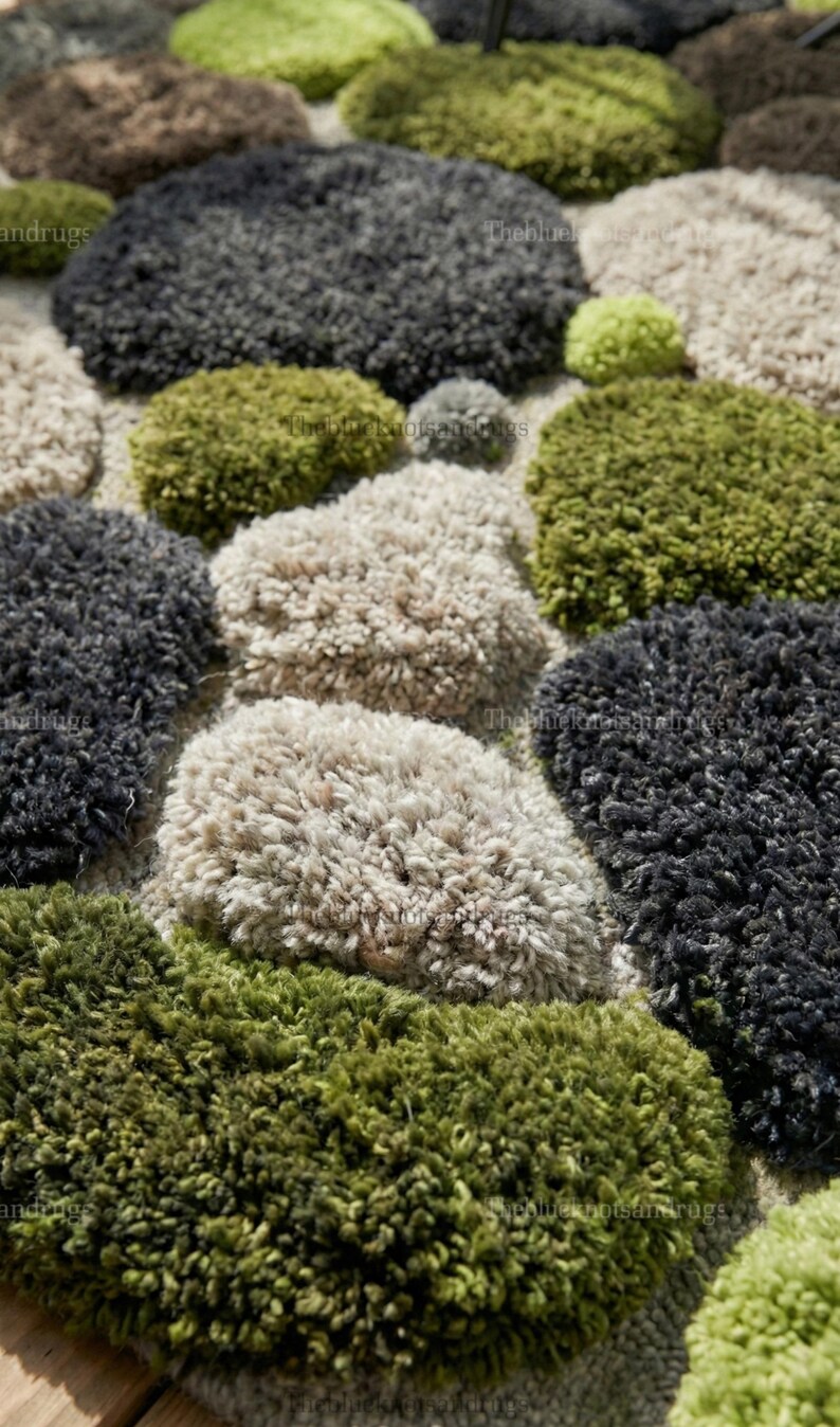 Modern hand-tufted beige wool rug with pebble pattern on balcony; 3D textured abstract carpet in gray, black, moss green.