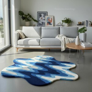 Hand-tufted wavy pattern rug in an irregular organic shape; ocean blue to navy blues with white cream, a textured plush melting rug.