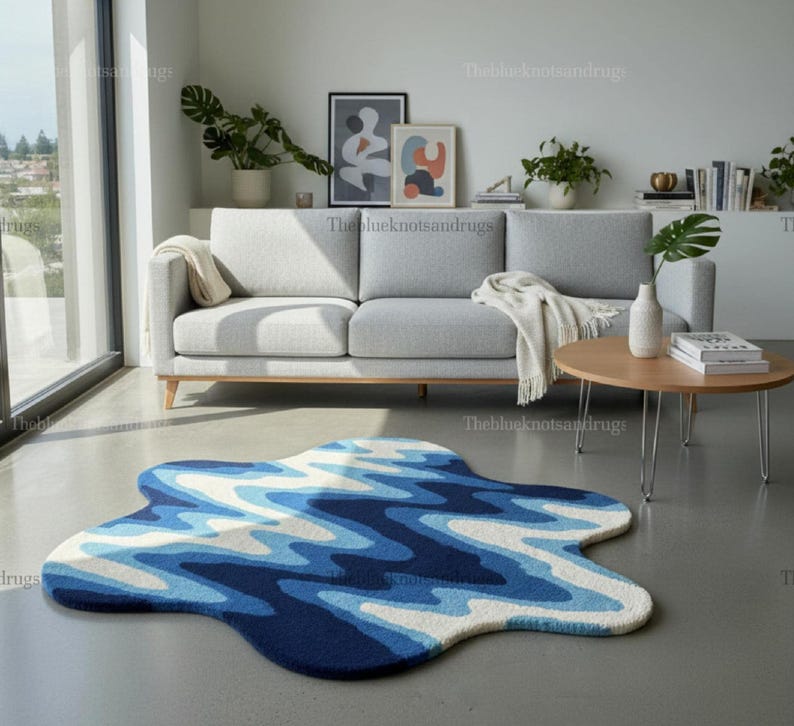 Hand-tufted wavy pattern rug in an irregular organic shape; ocean blue to navy blues with white cream, a textured plush melting rug.