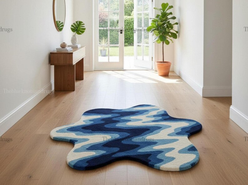 Hand-tufted wavy pattern rug in an irregular organic shape; ocean blue to navy blues with white cream, a textured plush melting rug.