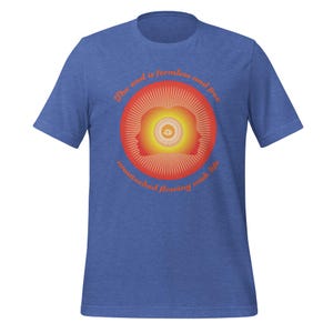 May include: Blue t-shirt with a circular graphic in shades of orange and yellow. The graphic features two stylized head profiles and an eye in the center, surrounded by radiating lines. Text around the circle reads "The soul is formless and free, unattached flowing with life."